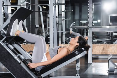 Beden eğitiminde bacak presi makinesinde egzersiz yapan Orta Doğu 'lu sporcunun yan görüntüsü 