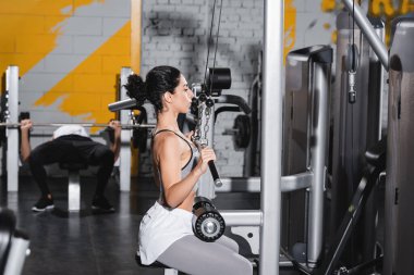 Spor salonunda dambıl eğitimi almış Orta Doğulu bir kadın. 
