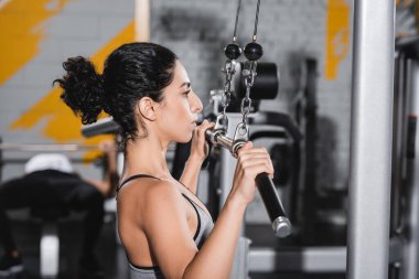 Orta Doğu 'lu sporcunun spor salonunda spor yaparken yandan görünüşü 