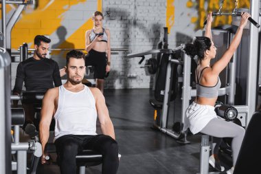Spor merkezinde ekipmanla çalışan ırklar arası gençler. 
