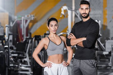 Orta Doğu 'lu genç sporcu spor salonundaki Arap arkadaşının yanındaki kameraya bakıyor. 