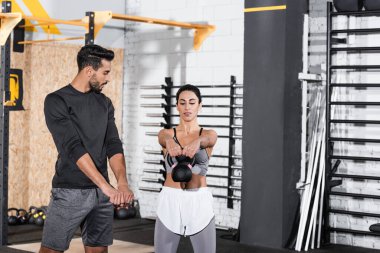 Spor merkezinde Müslüman antrenörlerin yanında kettlebell ile Orta Doğu sporcusu eğitimi. 