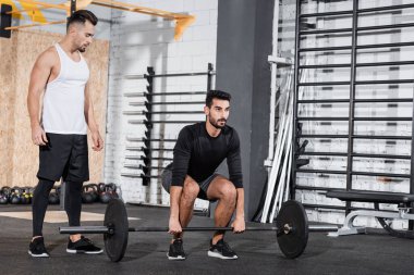 Spor salonunda spor salonunun yanında halterli Arap sporcusu eğitimi. 