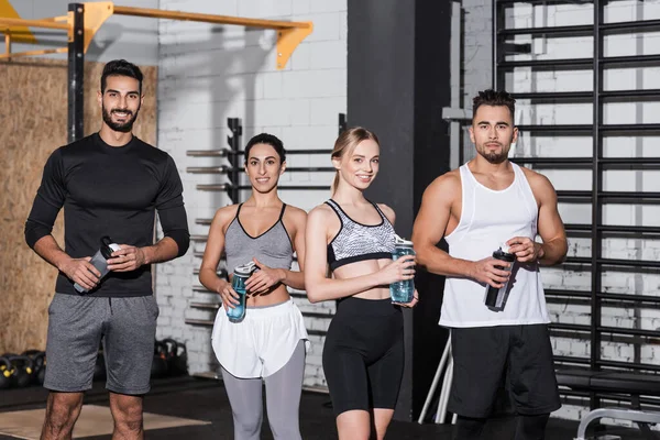 Smiling Interracial Sportsmen Sportswomen Holding Sports Bottles Gym —  Fotos de Stock