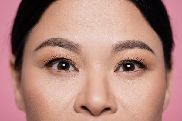 Cropped view of asian woman looking up isolated on pink 