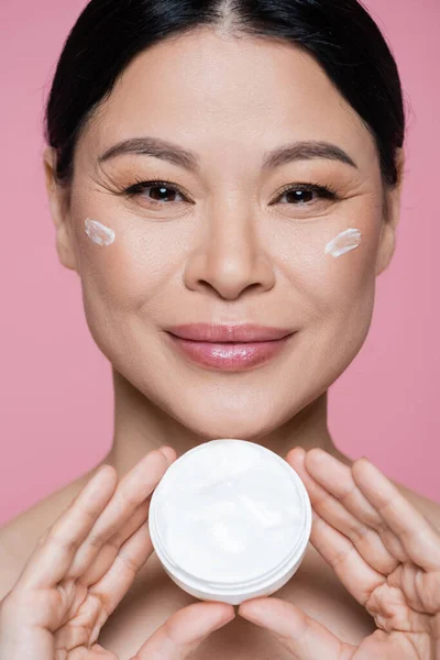 Positiv Asiatisk Kvinna Som Håller Kosmetisk Kräm Isolerad Rosa — Stockfoto