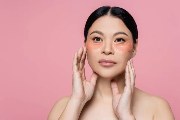 Göz Bantlı Asyalı Kadın Pembe Üzerine Izole Edilmiş Yüzlere Dokunuyor — Stok fotoğraf