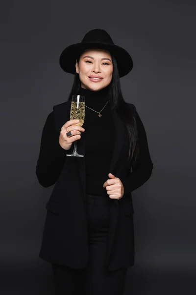 Позитивна Азіатська Жінка Капелюсі Фургори Тримає Шампанське Ізольовано Темно Сірому — стокове фото