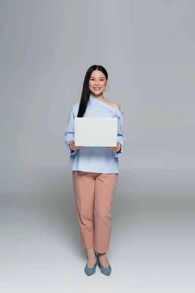 Positive Stylish Asian Woman Holding Laptop Grey Background — Stock Photo, Image