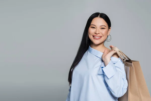 Positivo Ásia Mulher Blusa Segurando Compras Sacos Isolado Cinza — Fotografia de Stock