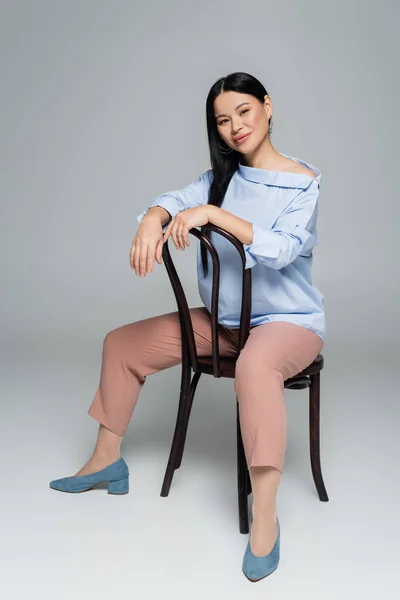 Sonriendo Mujer Asiática Mirando Cámara Mientras Está Sentado Silla Sobre —  Fotos de Stock