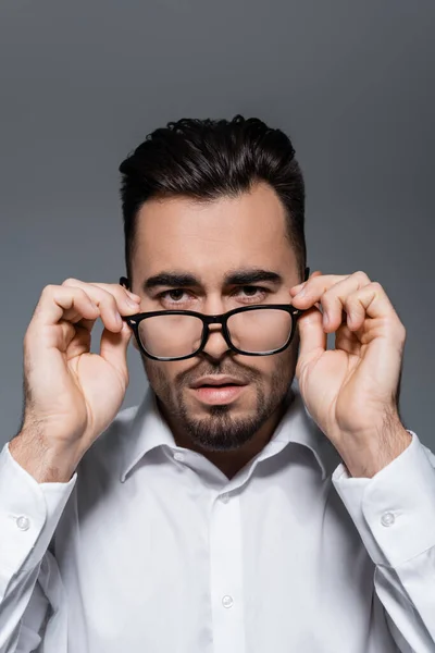 灰色で隔離された眼鏡を調整する白いシャツを着た髭のビジネスマン — ストック写真