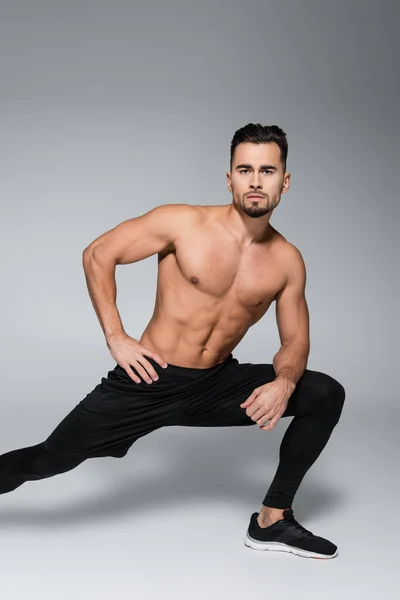 Joven Barbudo Musculoso Deportista Estirándose Sobre Gris —  Fotos de Stock