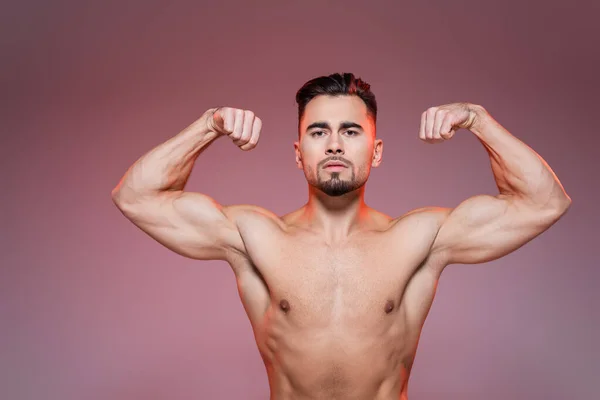 Beleuchtung Mann Ohne Hemd Zeigt Muskeln Auf Rosa Und Grau — Stockfoto