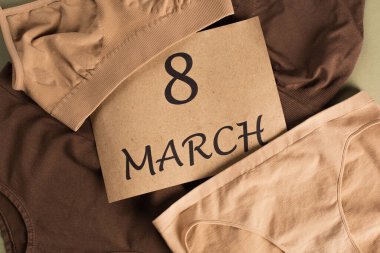 Yeşil arka planda pamuklu iç çamaşırı üzerine 8 Mart harfi yazılı en iyi kart görüntüsü 