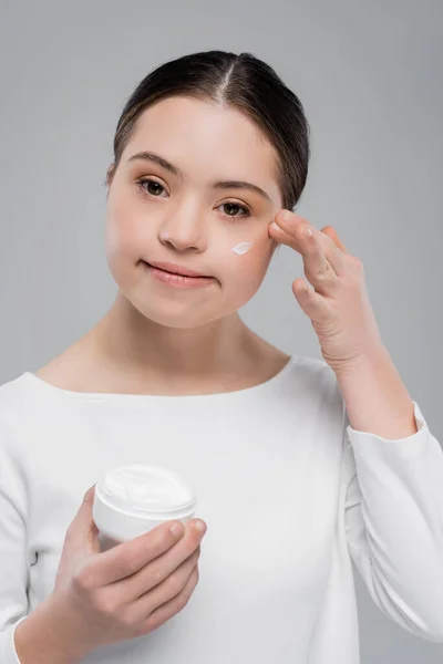 Jovem Com Síndrome Aplicando Creme Facial Isolado Cinza — Fotografia de Stock