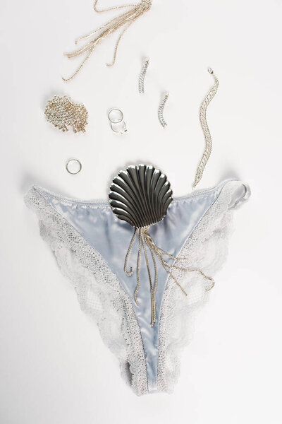 Top view of silk panties near accessories on white background 