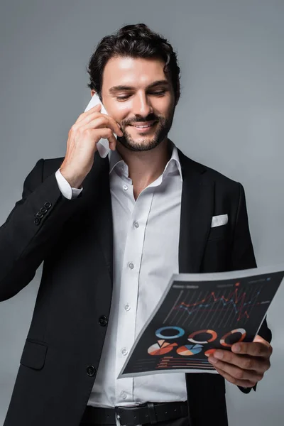 Homem Negócios Sorrindo Olhando Para Infográficos Falando Celular Isolado Cinza — Fotografia de Stock