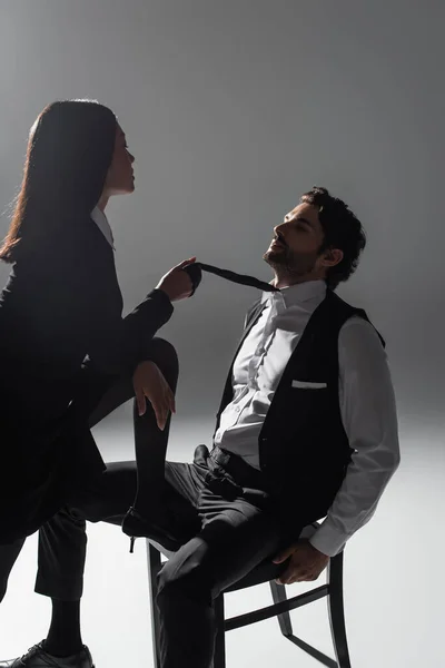 Hot Asian Woman Holding Tie Elegant Man Sitting Chair Grey — Stock Photo, Image