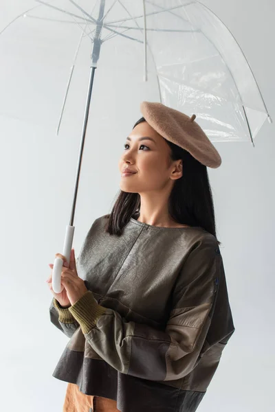 Positive Asiatische Frau Lederpullover Und Baskenmütze Schaut Weg Unter Transparentem — Stockfoto