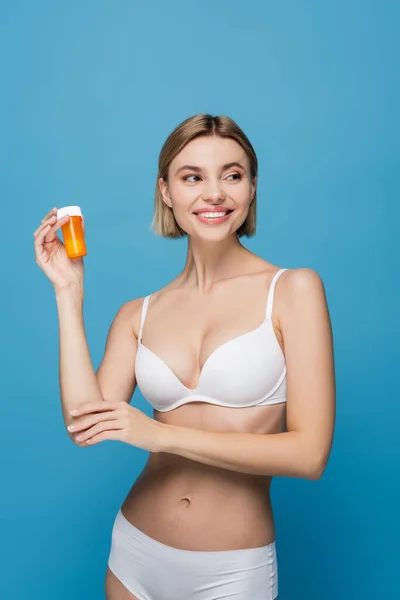 Glad Ung Kvinna Vita Underkläder Hålla Flaska Med Vitaminer Isolerade — Stockfoto