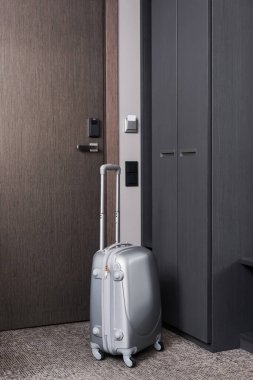 Modern otel odasında gri bavul 