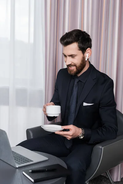 Cheerful Bearded Man Earphone Holding Cup Looking Laptop — Stock Photo, Image