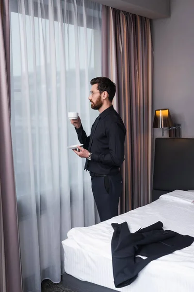 Bearded Man Eyeglasses Suit Holding Cup Coffee Hotel Room — Stock Photo, Image