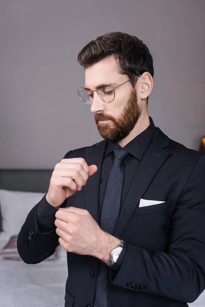 Bearded Man Eyeglasses Adjusting Sleeve Shirt Hotel Room — Stock Photo, Image