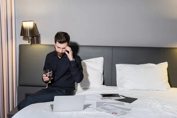 Man Met Baard Met Glas Whisky Kijkend Naar Laptop Hotel — Stockfoto