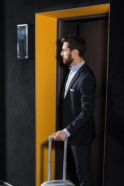 Bearded Man Suit Standing Luggage Hotel Corridor — Stock Photo, Image