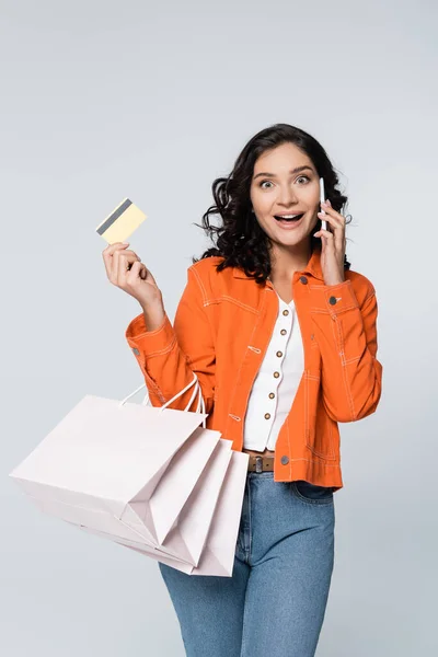 Mujer Sorprendida Hablando Teléfono Inteligente Mientras Sostiene Tarjeta Crédito Con —  Fotos de Stock