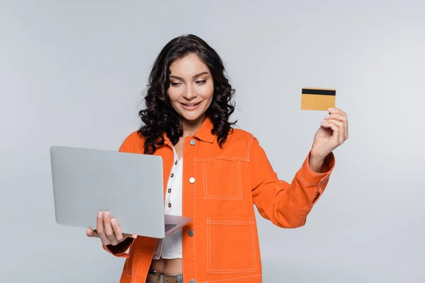 Mujer Joven Feliz Chaqueta Naranja Mirando Computadora Portátil Celebración Tarjeta —  Fotos de Stock