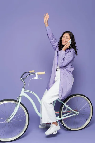 Mujer Feliz Impermeable Violeta Montar Bicicleta Agitar Mano Mientras Habla —  Fotos de Stock