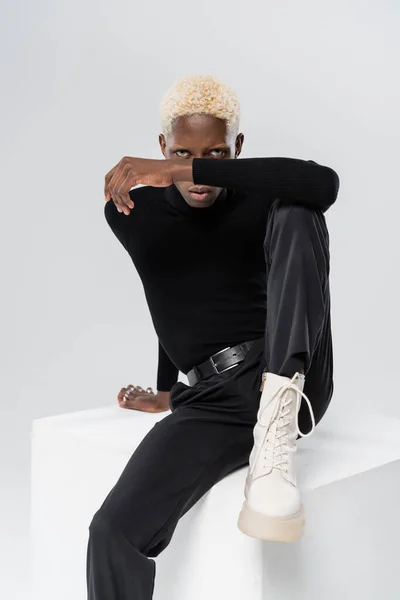Joven Africano Americano Hombre Elegante Traje Sentado Blanco Cubo Aislado — Foto de Stock