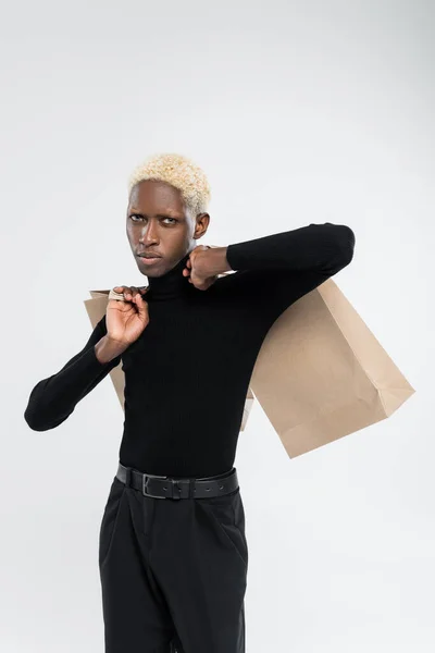 Αφροαμερικάνος Που Κρατάει Τσάντες Για Ψώνια Απομονωμένες Στο Γκρι — Φωτογραφία Αρχείου