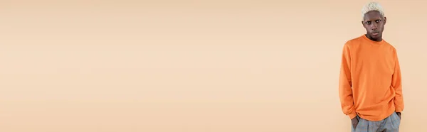 Блондинка Афроамериканка Помаранчевій Сорочці Позує Руками Кишенях Ізольовано Бежевому Банер — стокове фото