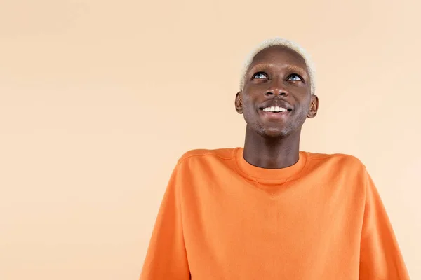 Hombre Afroamericano Feliz Sudadera Naranja Sonriendo Mientras Mira Hacia Arriba — Foto de Stock
