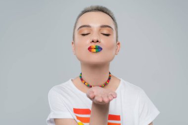 lgbt renginde dudakları olan genç bir kadın hava öpücüğü üflüyor. Gri renkte.