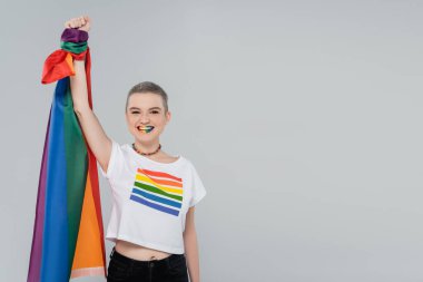 Neşeli kadın lgbt bayrağını tutarken elini griye kaldırdı.