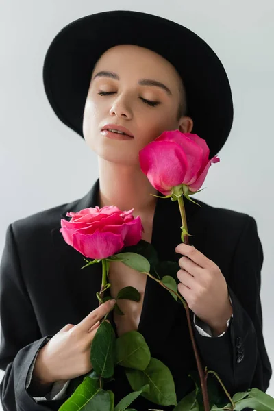 Zmysłowa Młoda Kobieta Zamkniętymi Oczami Trzymająca Świeże Różowe Róże Odizolowane — Zdjęcie stockowe