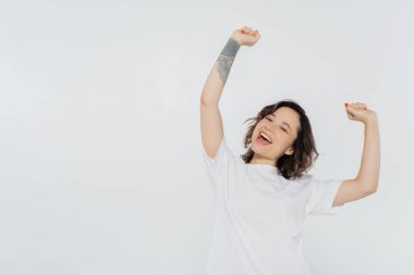 Neşeli esmer kadın evet işareti yapıyor. Gri, feminizm kavramına izole edilmiş.
