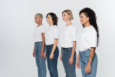 Beyaz tişörtlü ırklar arası kadınlar, gri feminizm kavramına izole edilmiş bir şekilde bakışlarını kaçırıyorlar.
