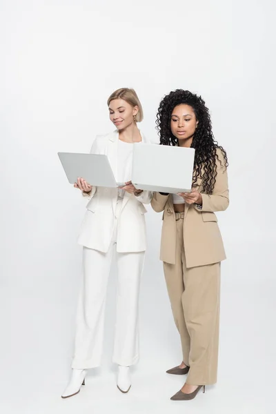 Volledige Lengte Van Stijlvolle Interraciale Zakenvrouwen Met Behulp Van Laptops — Stockfoto