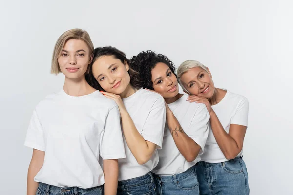 Mulheres Multiétnicas Positivas Abraçando Umas Outras Olhando Para Câmera Isolada — Fotografia de Stock