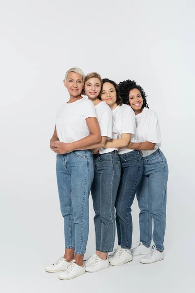 全长笑容满面的多民族女性拥抱在灰色背景下 女性主义的概念 — 图库照片
