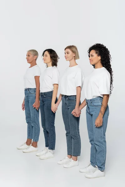 Multiethnic Women Holding Hands Looking Away Grey Background — Stock Photo, Image