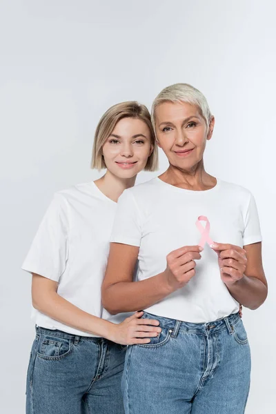 Mulher Sorridente Abraçando Amigo Sênior Com Fita Consciência Câncer Mama — Fotografia de Stock