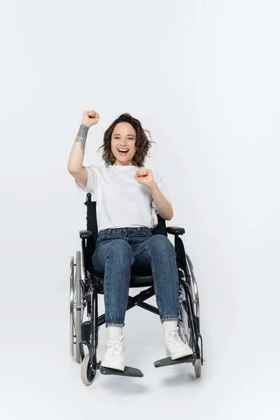 Возбужденная Женщина Инвалидной Коляске Показывает Жест Сером Фоне — стоковое фото