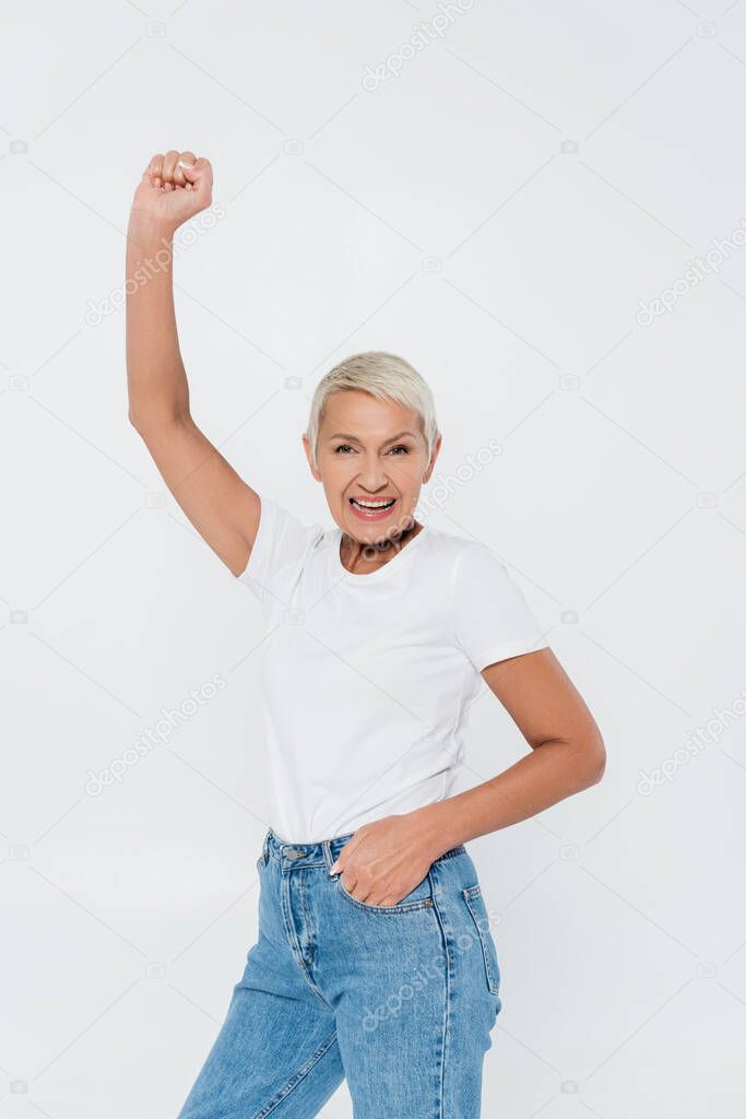 Excited senior woman showing yes gesture isolated on grey, feminism concept